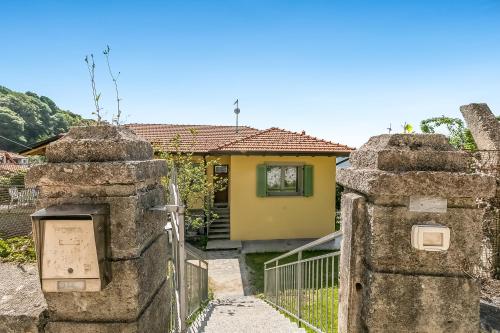 a yellow house with a gate and a fence at Residenza Quadrifoglio in Casalzuigno