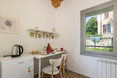 a kitchen with a desk and a window at Residenza Quadrifoglio in Casalzuigno