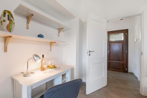 a white room with a desk and a chair at Residenza Quadrifoglio in Casalzuigno
