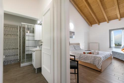 a white bedroom with a bed and a bathroom at Residenza Quadrifoglio in Casalzuigno