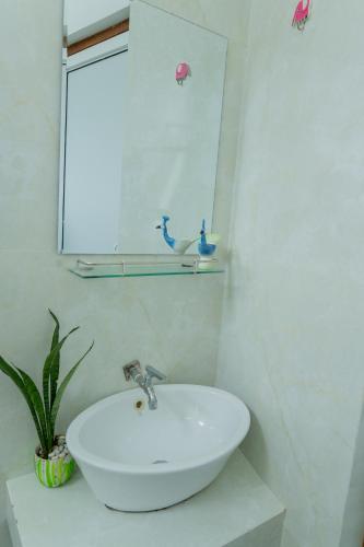 a bathroom with a white sink and a mirror at Villa 83 in Nedimale