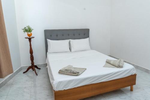 a bed with white sheets and towels on it at Villa 83 in Nedimale