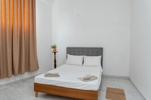a bedroom with a bed with white sheets and an orange curtain at Villa 83 in Nedimale