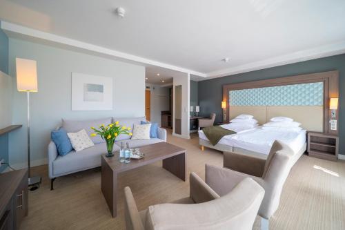 a hotel room with a bed and a living room at Hotel Perła Południa in Rytro