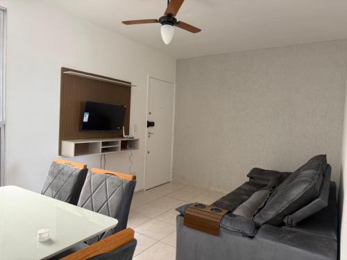 a living room with a couch and a ceiling fan at Apto 2 quarto Completo com Vaga in Contagem