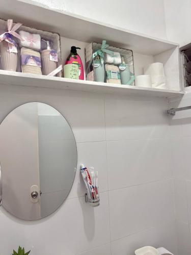 a bathroom with a mirror and a shelf with toiletries at Budget Loft-type condo in Uptown CDO in Cagayan de Oro