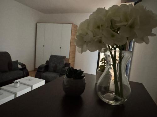 a vase with flowers on a table in a living room at Centar Sweet Home in Šabac