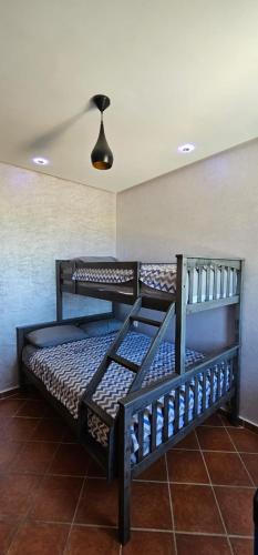 two bunk beds in a room with a ceiling at Superbe apartment en residence with pool in Cabo Negro