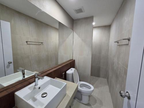 a bathroom with a sink and a toilet and a mirror at Hommory Residence - Phuket Town in Ban Lo Long