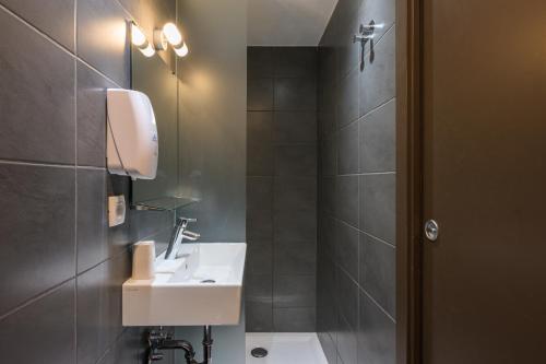 a bathroom with a sink and a shower at ATIK ROOMS in Ljubljana