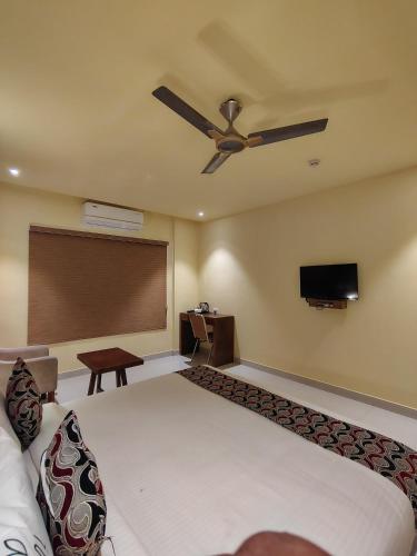 a hotel room with a bed and a ceiling fan at Ambal Regency in Pudukād