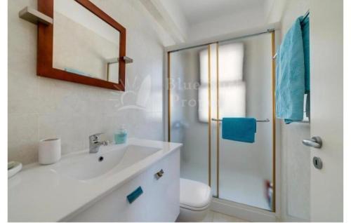 een witte badkamer met een wastafel en een douche bij Villa Enaria Serene 3Bdr Retreat in Ayia Thekla in Ayia Napa