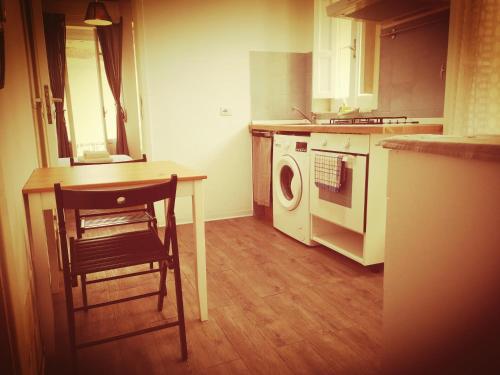 a kitchen with a table and a washing machine at Stanze a Sud in Ragusa