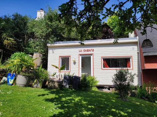 a white tiny house in a yard at La cabane zen in Saint-Martin-des-Champs