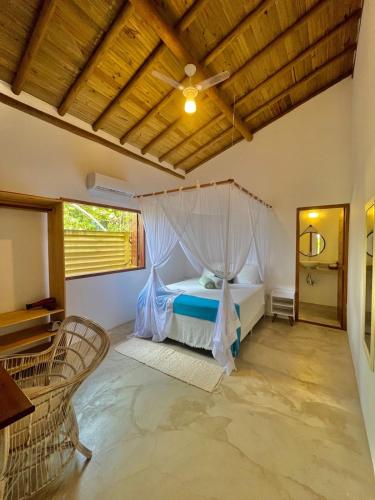 a bedroom with a bed with a mosquito net at CASA RENASCER in Trancoso