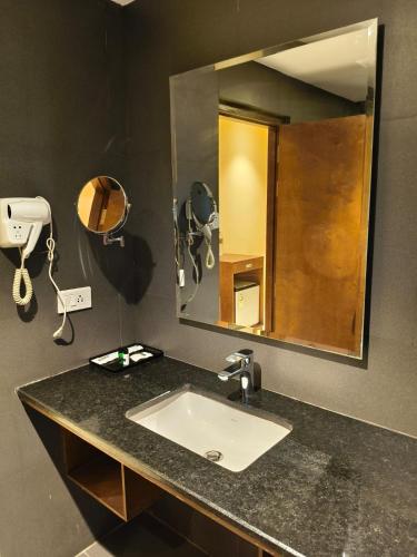 a bathroom with a sink and a mirror at Ambal Regency in Pudukād