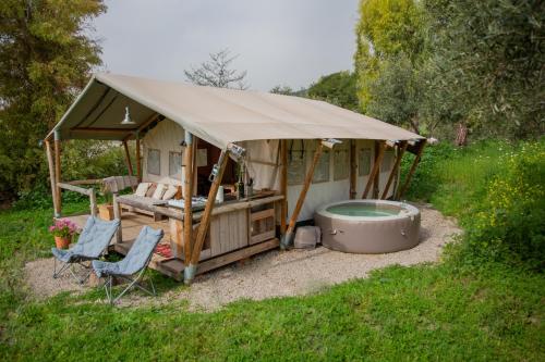 ein Pavillon mit Wanne, Bett und Stühlen in der Unterkunft Tienda de Safari Almagro in Montecorto