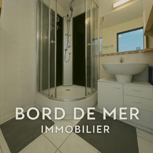 une salle de bain avec une douche, un lavabo et un miroir dans l'établissement Marine Escape, à Aresquies