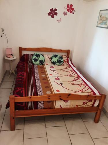 a bed with a wooden frame in a room at Chez Marie france in Saint-Paulien