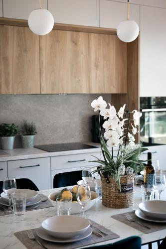 a kitchen with a table with plates and wine glasses at BURSZTYN - BERNSTEIN APARTMENTS in Dąbki