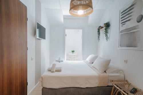 a white bedroom with a bed in a room at מלון סנטרל ביץ תל אביב in Tel Aviv