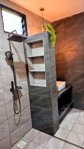 a bathroom with a sink and a shower at Villa Aisya in Kampung Padang Masirat