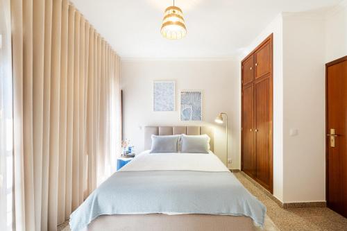 a bedroom with a large bed and a window at Villa 5 in Vila do Conde