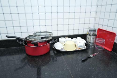a stove top with a pot and dishes on a counter at Newly built Spacious & Luxurious 1650 sft 2BHK with AC, fully functional kitchen, car parking in Tirupati near Railway Station in Tirupati