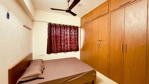 a bedroom with a bed and a ceiling fan at Newly built Spacious & Luxurious 1650 sft 2BHK with AC, fully functional kitchen, car parking in Tirupati near Railway Station in Tirupati