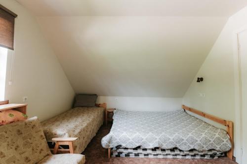a room with two beds and a couch at Lejasbisenieki in Turaida