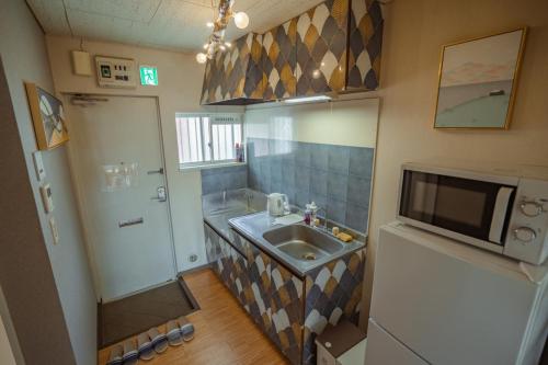 a small bathroom with a sink and a tv at コ一ボ箱根 箱根中心 in Hakone