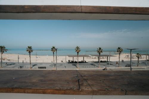 a view of a beach with palm trees and the ocean at מלון סנטרל ביץ תל אביב in Tel Aviv