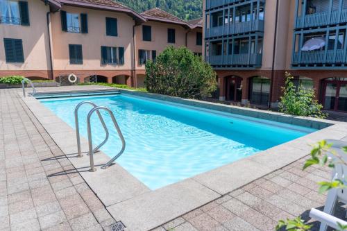 a swimming pool in front of a building at Surfers Lodge with Beach, near Interlaken in Därligen