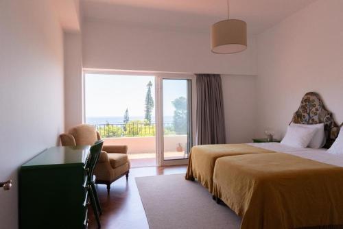 a bedroom with two beds and a desk and a window at Fatima`s House in Funchal