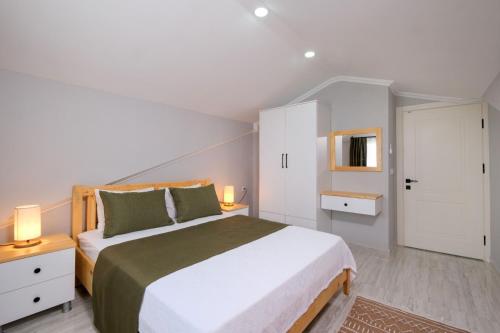 Un dormitorio con una cama grande y dos lámparas. en Roombnb Suıt, en Fethiye
