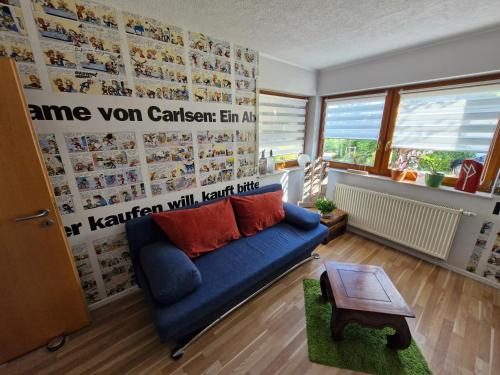 a living room with a blue couch and a table at Ferienwohnung Spirou in Waldesch