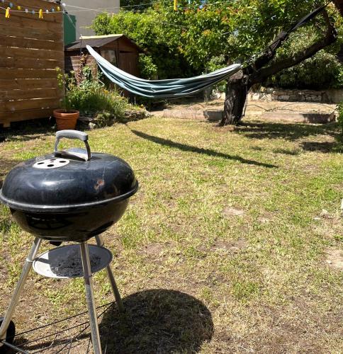 a grill in a yard with a hammock in the background at Le dindouleto in Peynier