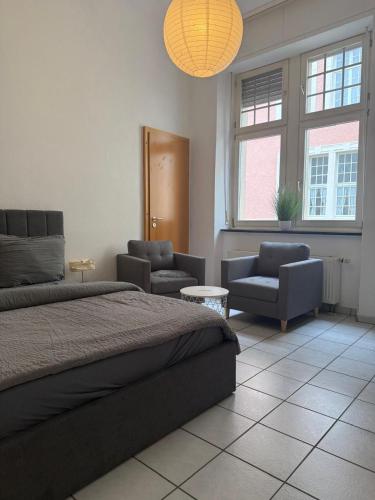 a bedroom with a bed and a couch and chairs at Ferienwohnungen am Gestade Wohnung 3 in Bernkastel-Kues