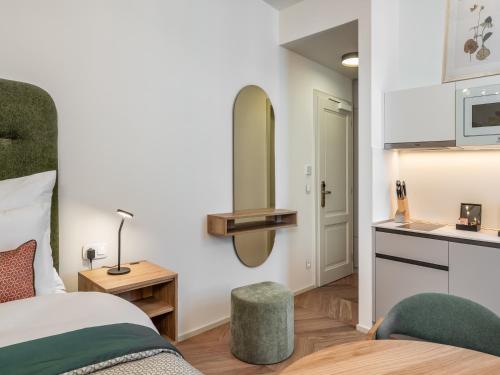 a bedroom with a bed and a sink and a mirror at The Botanist by Adrez in Prague