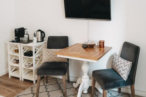a dining room table with two chairs and a desk at Boutique Hotel Villa Monika in Westerland (Sylt)