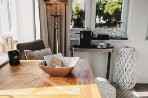 a wooden table with a bowl on top of it at Boutique Hotel Villa Monika in Westerland (Sylt)