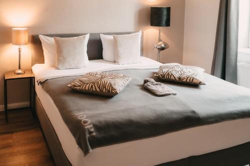 a large bed with two pillows on top of it at Boutique Hotel Villa Monika in Westerland (Sylt)