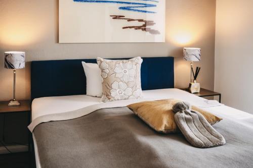 a bedroom with a bed with a blue headboard at Boutique Hotel Villa Monika in Westerland (Sylt)