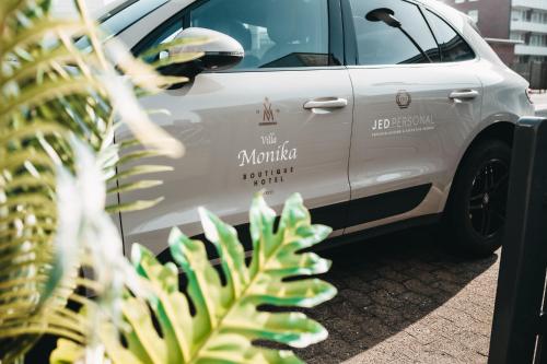 a white van parked in a parking lot with a palm tree at Boutique Hotel Villa Monika in Westerland (Sylt)