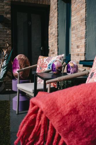 a patio with two chairs and a table with a red blanket at Boutique Hotel Villa Monika in Westerland (Sylt)