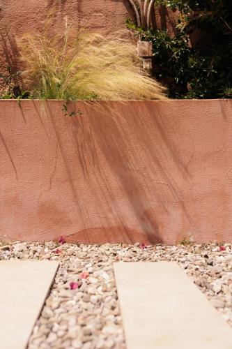 a garden with a retaining wall and some rocks at Dominoes Corfu in Ýpsos