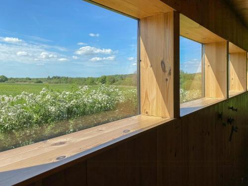 a window in a building with a view of a field at Tiny House By Bjerregrav Marsh And Nature in Randers