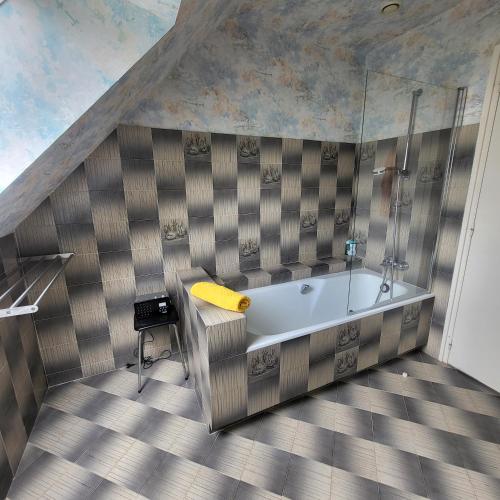 une salle de bain avec baignoire dans une chambre dans l'établissement Maison de KERLEVEN PLAGE, à La Forêt-Fouesnant