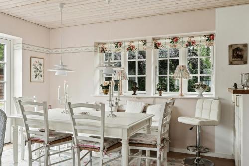 a dining room with a white table and chairs at Guest House By Lake And Forest in Nakskov