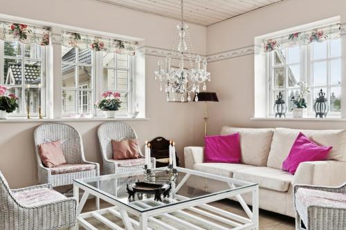 a living room with a white couch and pink pillows at Guest House By Lake And Forest in Nakskov
